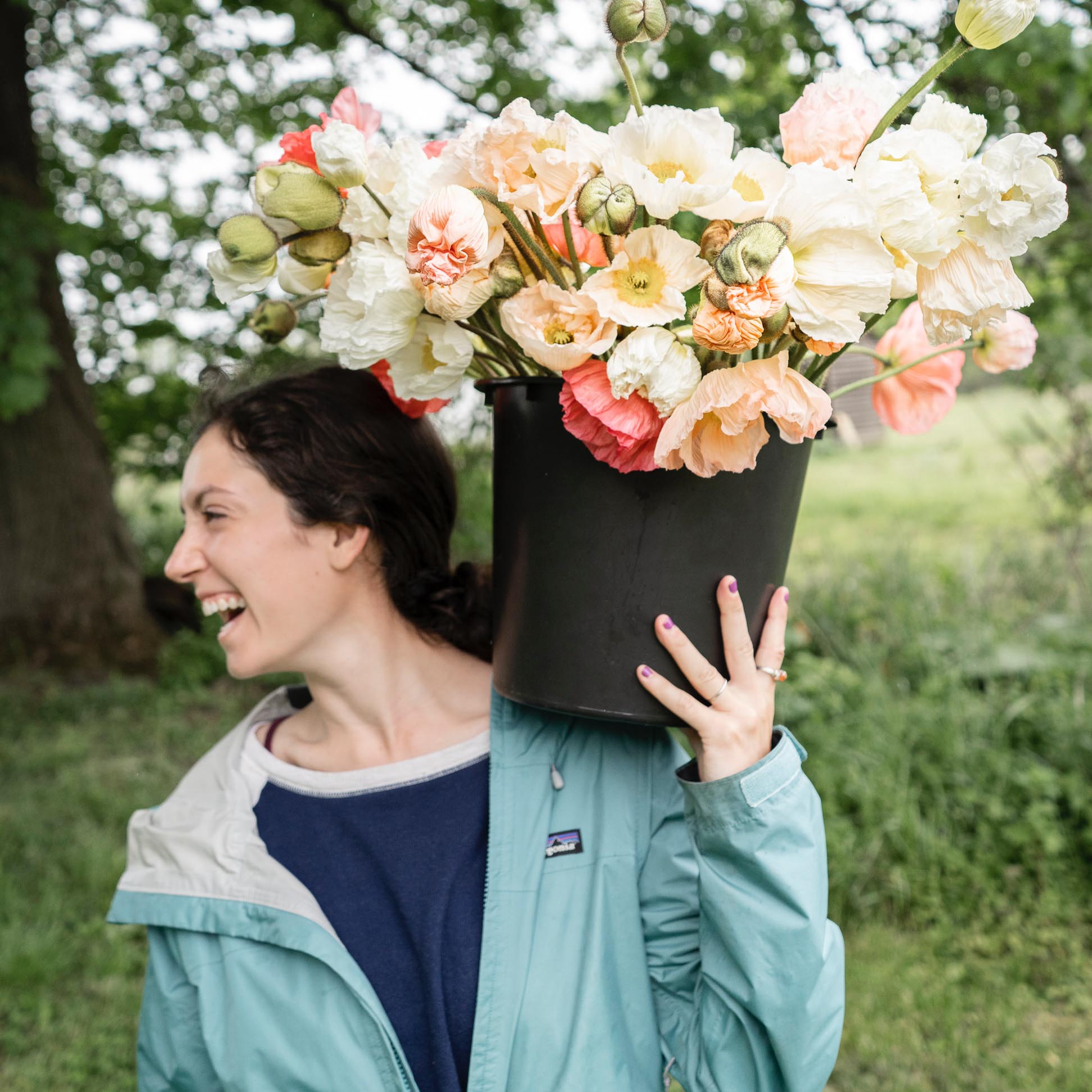 Maria laughing while holding a bucket full of fresh flowers