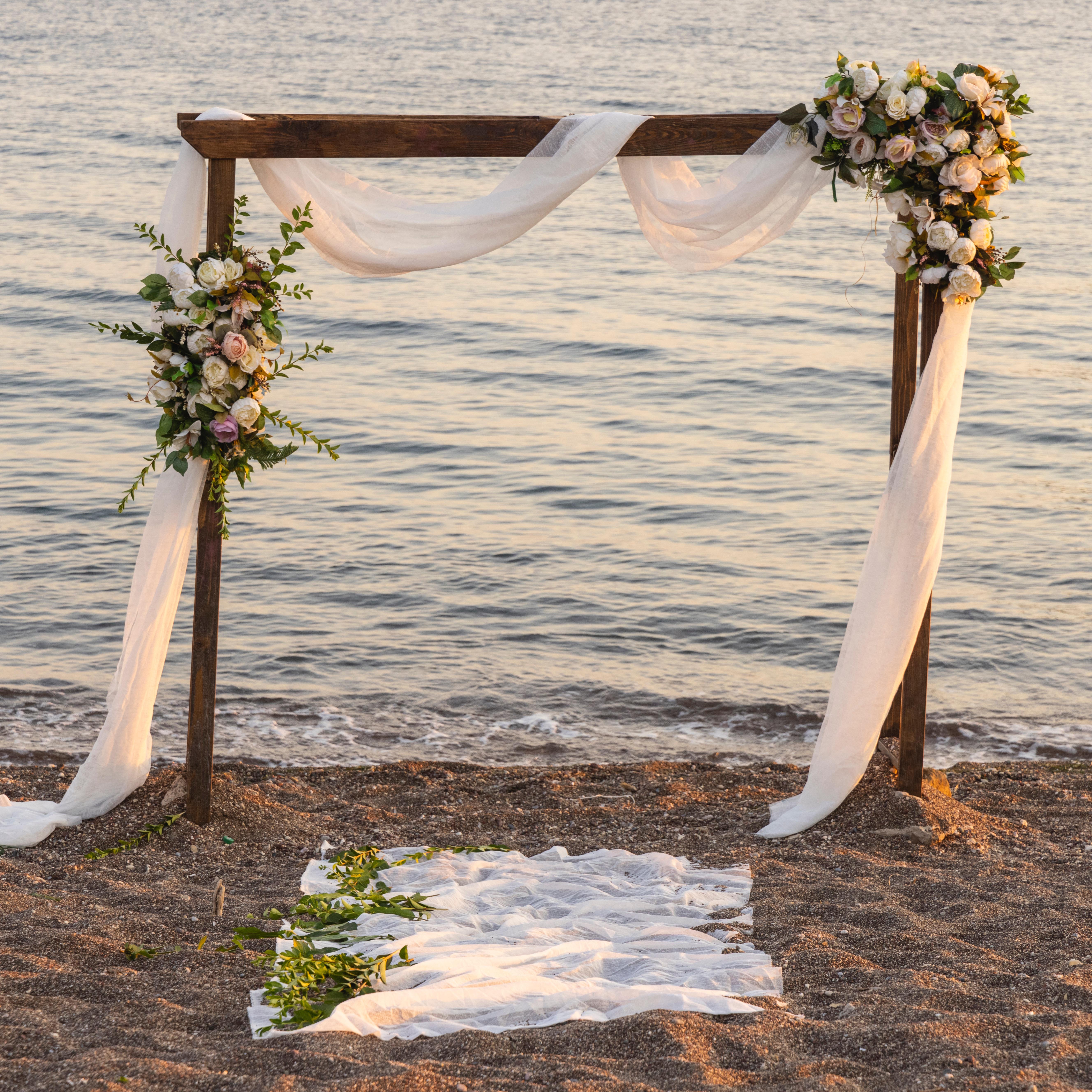 wedding wooden arch with beautiful flower arrangement at the beach